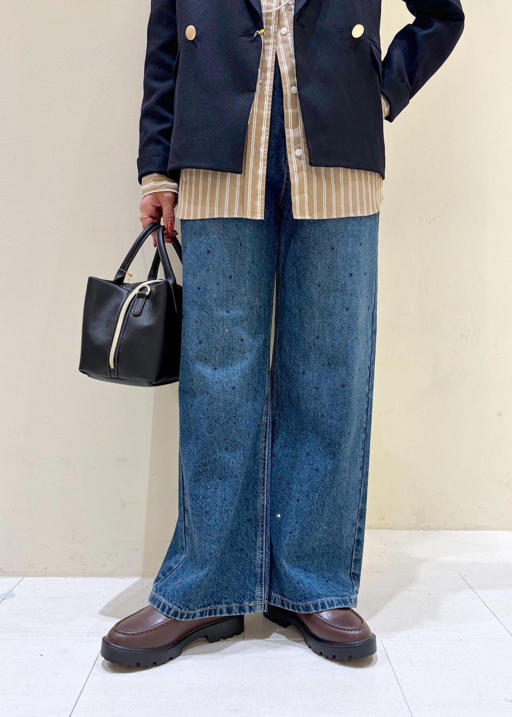 ブルー系のデニムパンツ、ブラウン系のローファー、ブラック系のトートバッグを着用したレディースの秋コーディネートの8枚目の写真