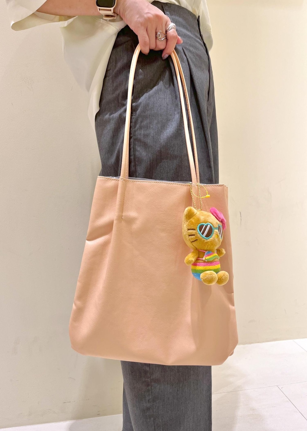 ピンク系のトートバッグ、グレー系のチノパンツ、ホワイト系のシャツ/ブラウスを着用したレディースの夏コーディネートの7枚目の写真