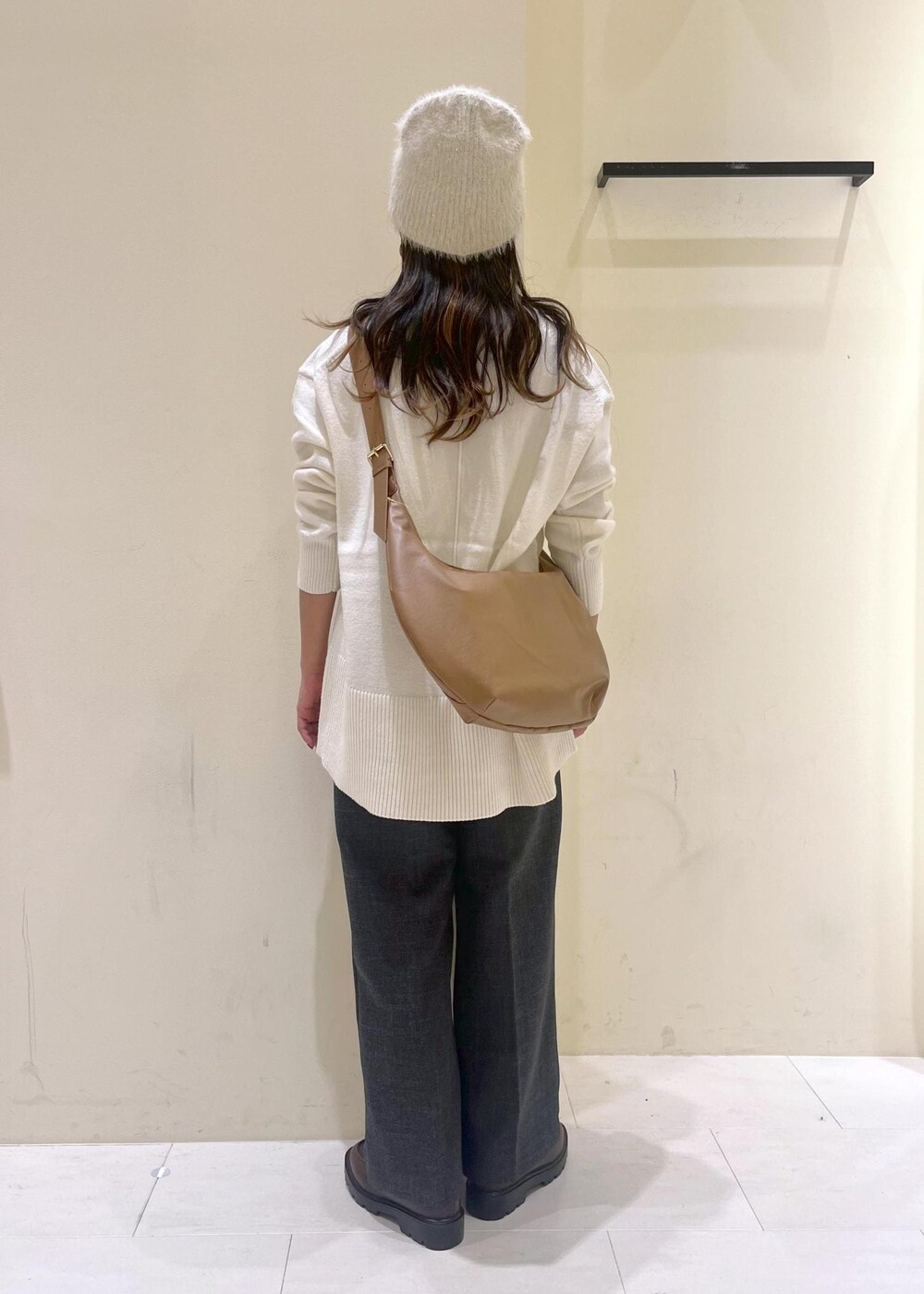ホワイト系のニット/セーター、グレー系のスラックス、ブラウン系のローファーを着用したレディースの冬コーディネートの3枚目の写真