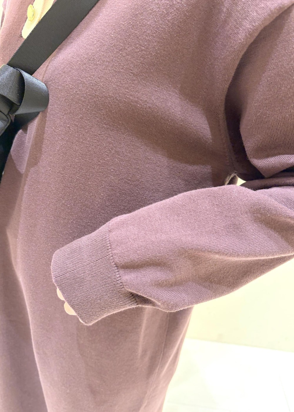 ブラウン系のワンピース、ブラック系のボディバッグ/ウエストポーチ、ホワイト系のスニーカーを着用したレディースの冬コーディネートの6枚目の写真