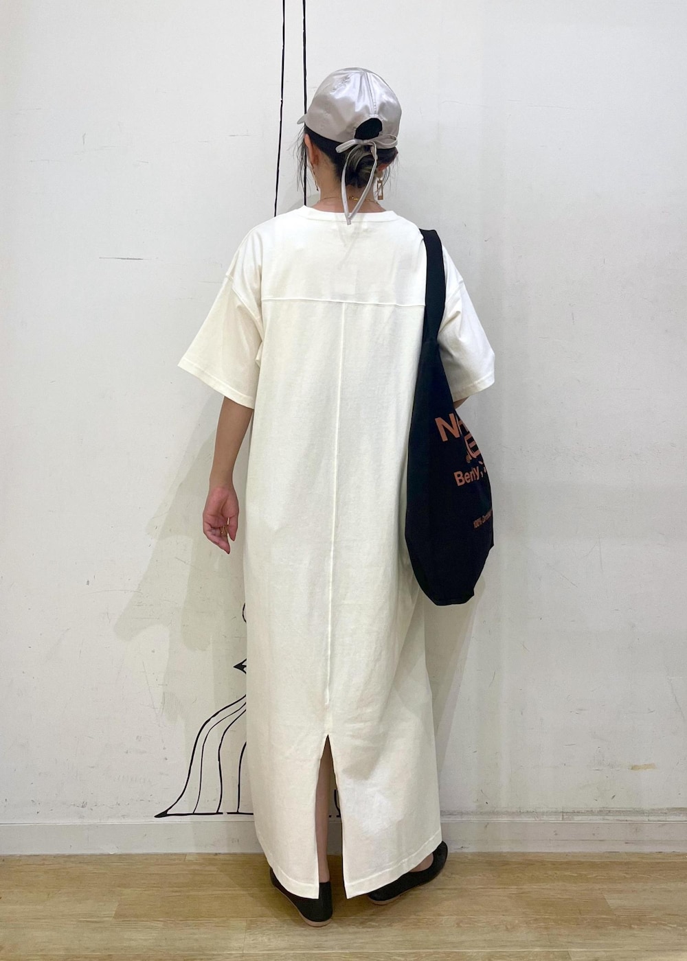 ブラック系のトートバッグ、ブラック系のバレエシューズ、ホワイト系のワンピースを着用したレディースの夏コーディネートの3枚目の写真