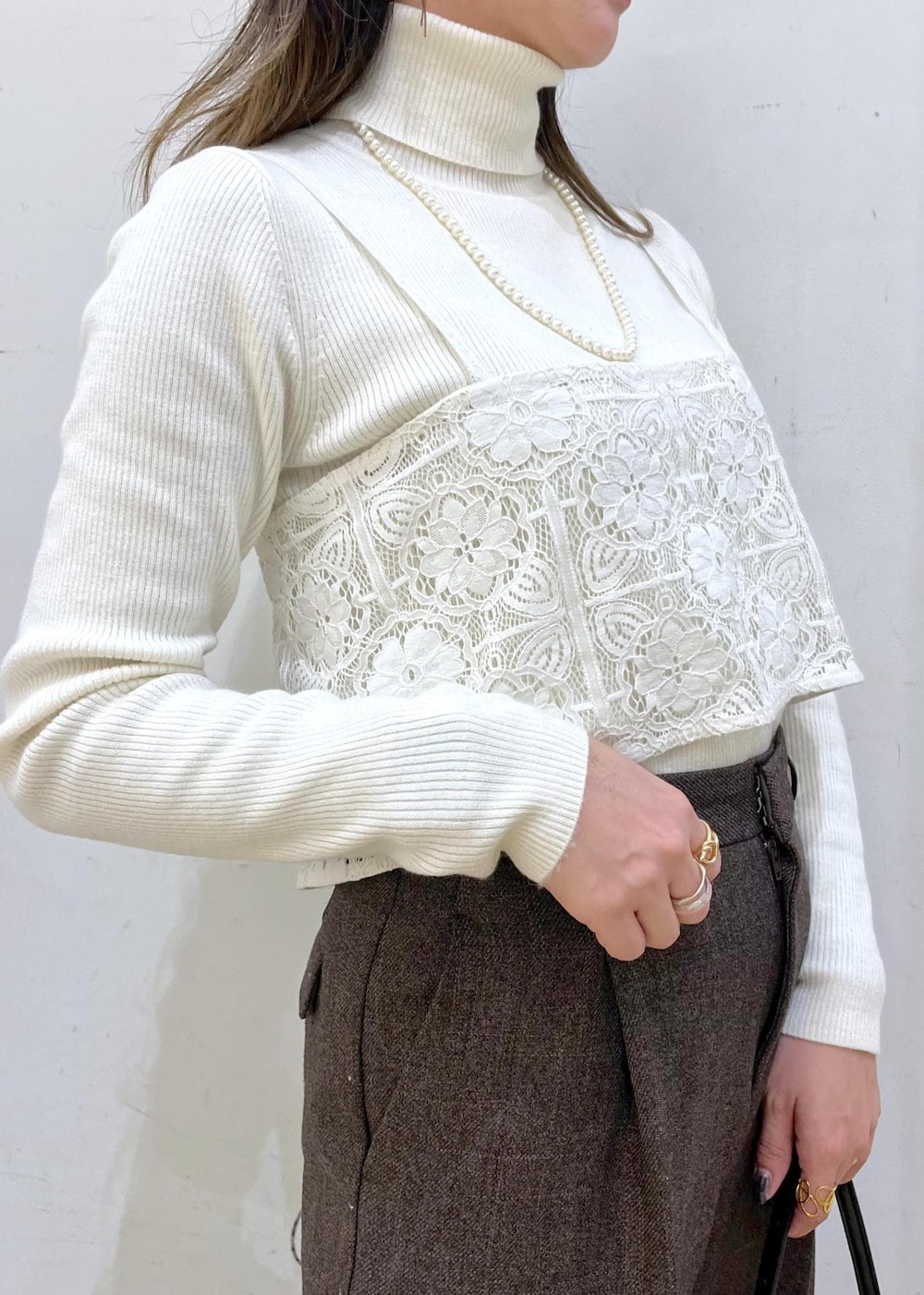 ホワイト系のニット/セーター、グリーン系のその他アウター、ブラウン系のその他パンツを着用したレディースの冬コーディネートの2枚目の写真