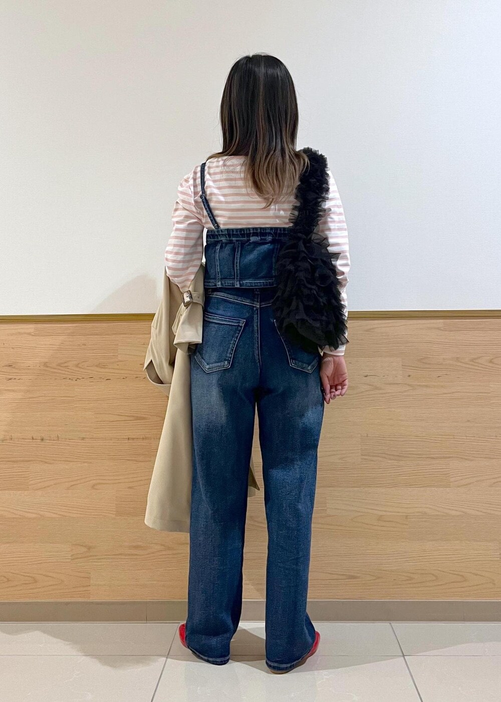 ブルー系のデニムパンツ、ブラック系のショルダーバッグ、ピンク系のTシャツ/カットソーを着用したレディースの春コーディネートの4枚目の写真