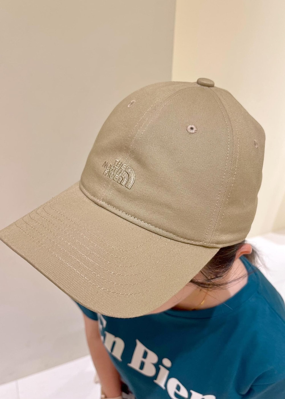 ホワイト系のトートバッグ、ホワイト系のサンダル、ブラック系のワンピースを着用したレディースの夏コーディネートの5枚目の写真