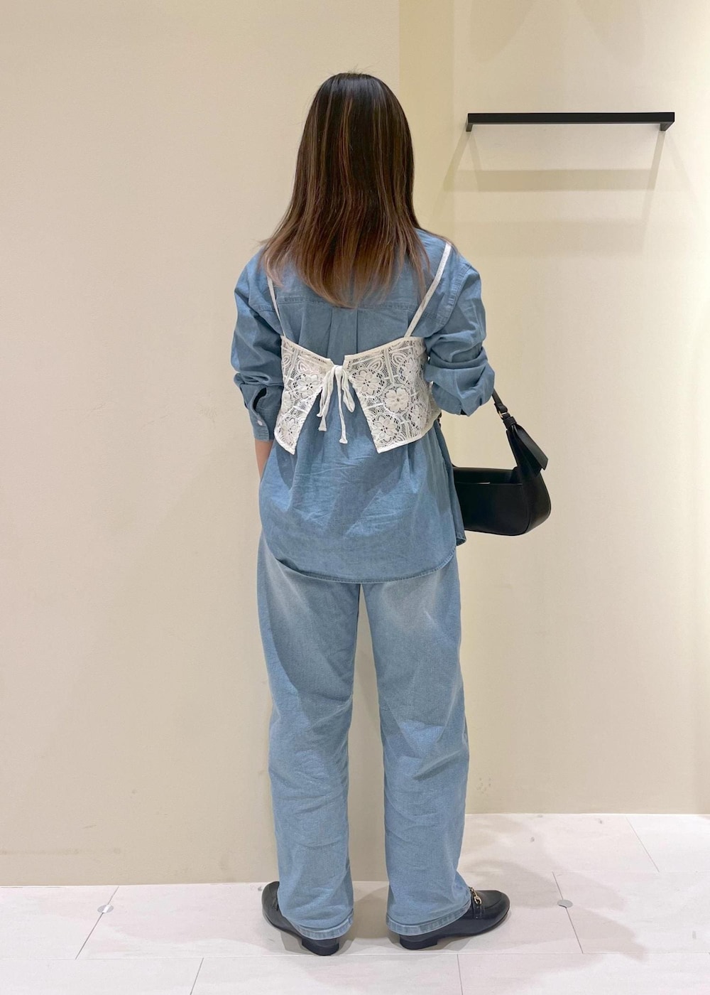 ブルー系のデニムパンツ、ホワイト系のキャミソール、ブラック系のハンドバッグを着用したレディースの春コーディネートの4枚目の写真