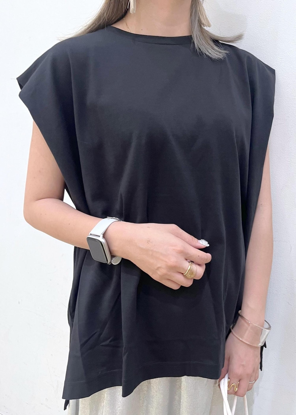 シルバー系のスカート、ブラック系のTシャツ/カットソー、ホワイト系のサンダルを着用したレディースの夏コーディネートの5枚目の写真