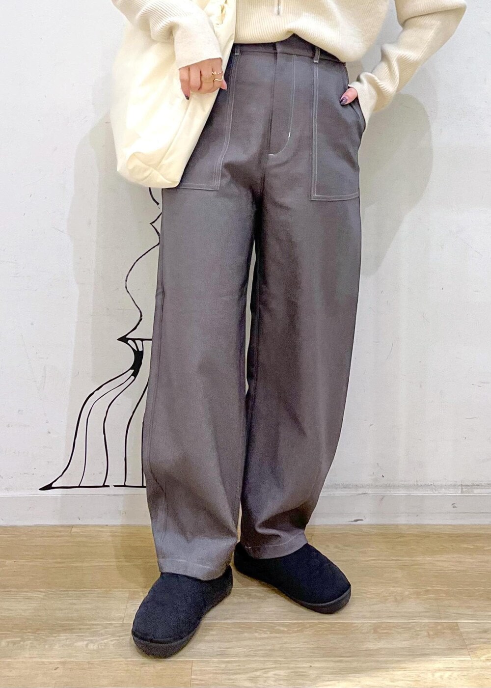 ベージュ系のニット/セーター、ホワイト系のトートバッグ、ブラック系のスリッポンを着用したレディースの冬コーディネートの7枚目の写真