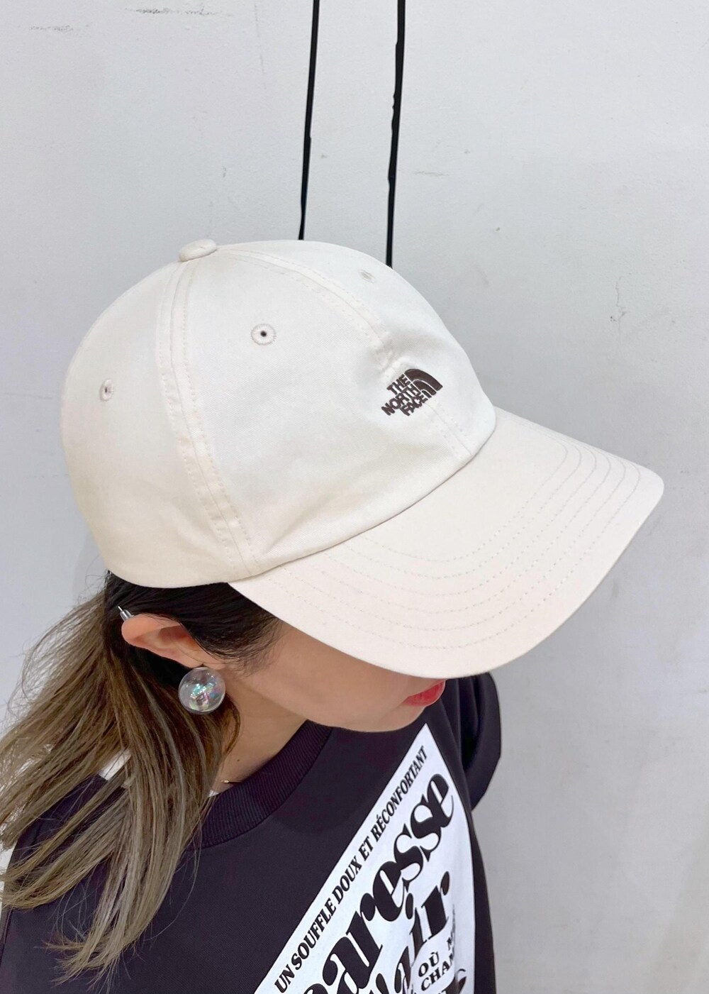 シルバー系のトートバッグ、ブラック系のサンダル、グレー系のTシャツ/カットソーを着用したレディースの夏コーディネートの8枚目の写真