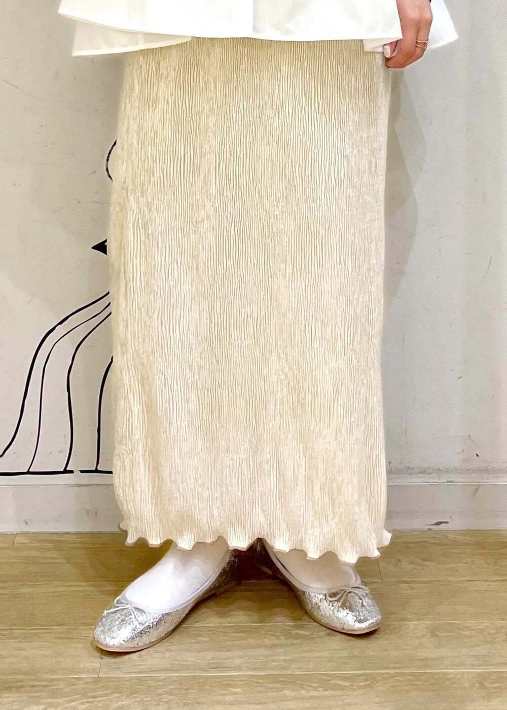 ベージュ系のハンドバッグ、ホワイト系のニット/セーター、シルバー系のバレエシューズを着用したレディースの冬コーディネートの8枚目の写真