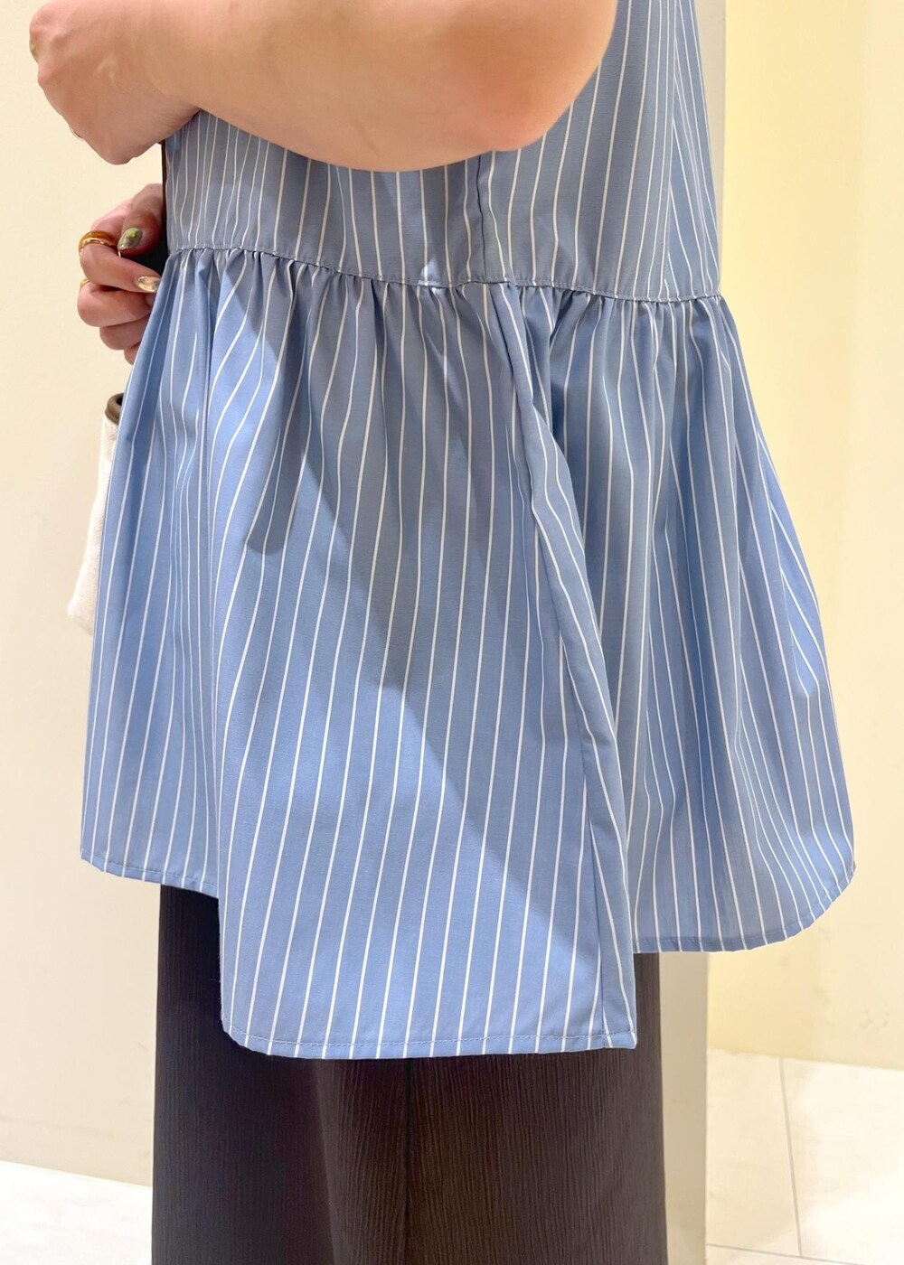 グレー系のタンクトップ、グレー系のワンピース、ブルー系のシャツ/ブラウスを着用したレディースの春コーディネートの6枚目の写真