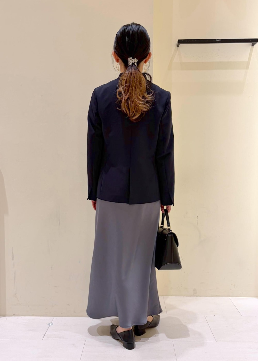 ホワイト系のシャツ/ブラウス、ブルー系のノーカラージャケット、ブラック系のショルダーバッグを着用したレディースの冬コーディネートの4枚目の写真