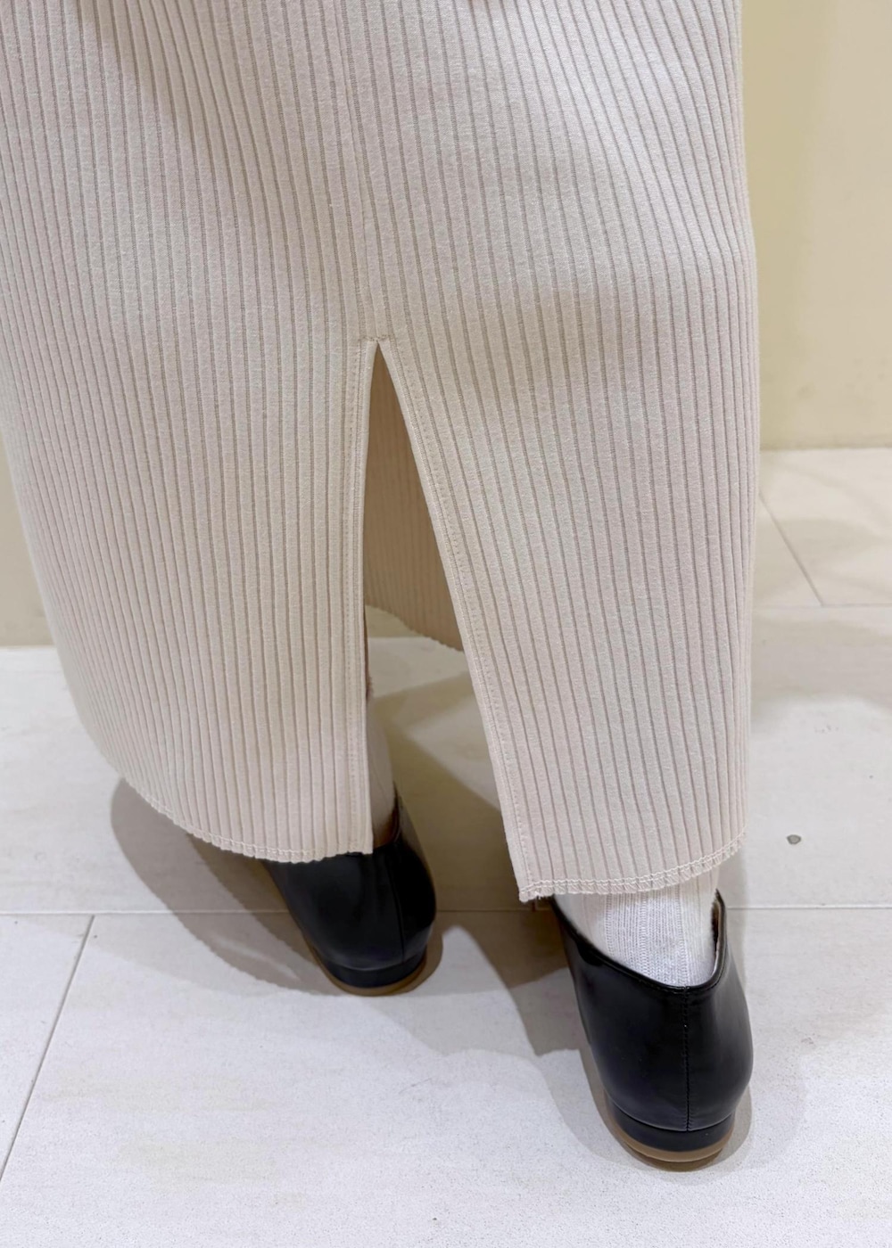 ブラック系のショルダーバッグ、ブラック系のパンプス、ホワイト系のスカートを着用したレディースの春コーディネートの8枚目の写真