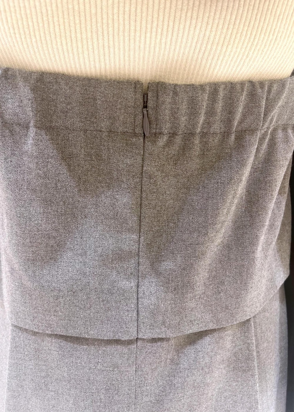 レッド系のショルダーバッグ、ホワイト系のニット/セーター、グレー系のワンピースを着用したレディースの秋コーディネートの6枚目の写真