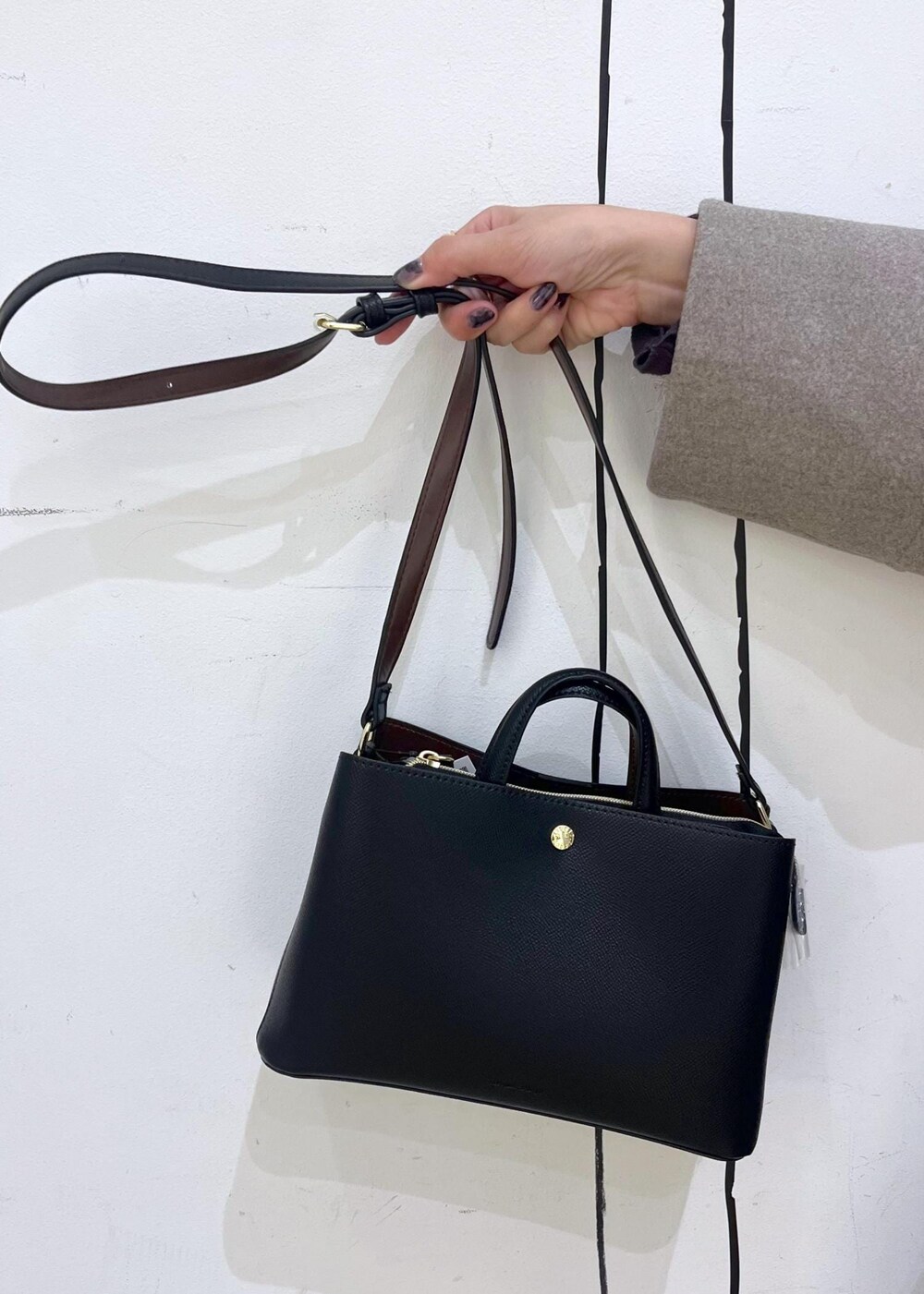 グレー系のTシャツ/カットソー、ベージュ系のカーディガン/ボレロ、ブラック系のブーツを着用したレディースの秋コーディネートの9枚目の写真