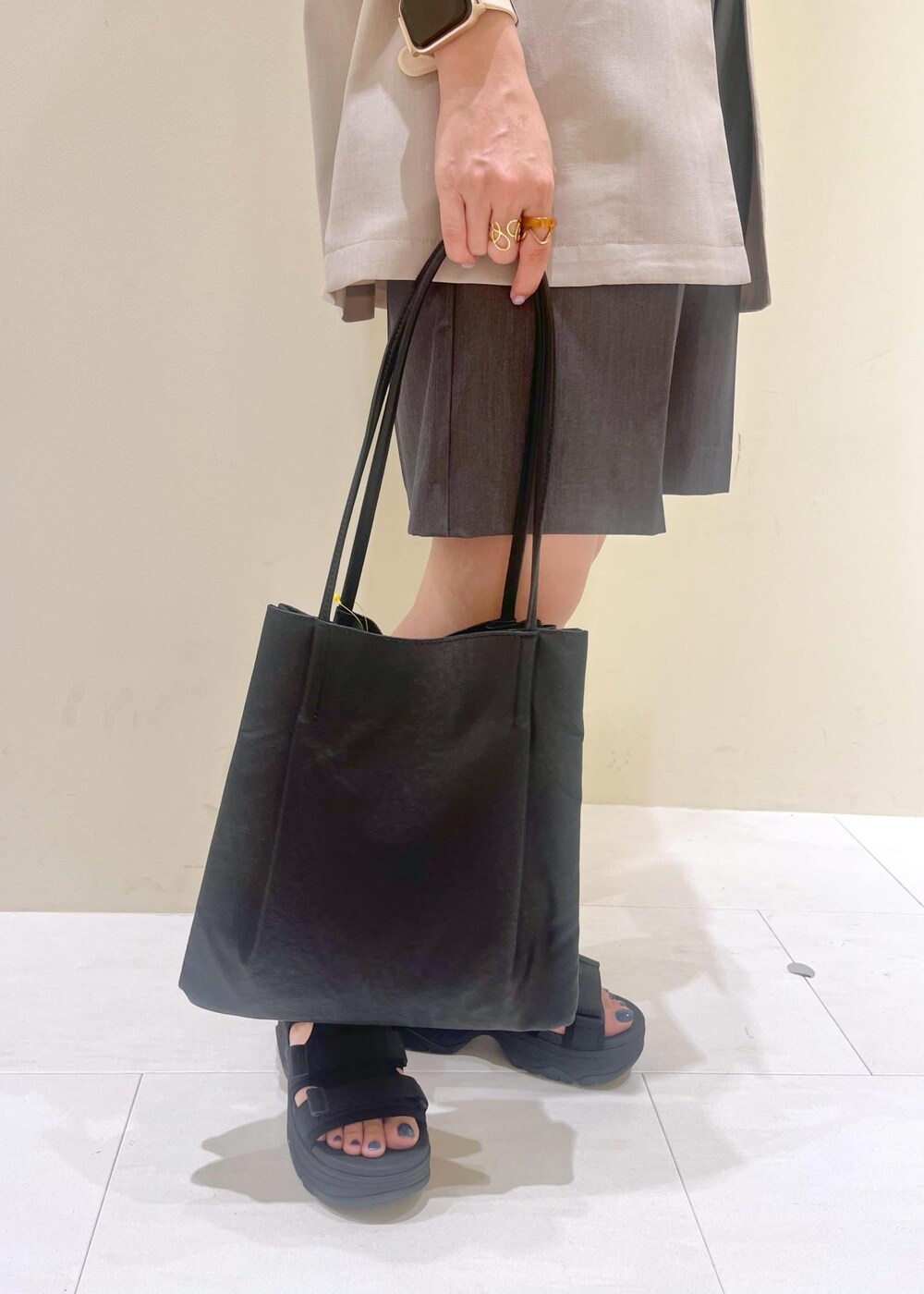 ブラック系のトートバッグ、グレー系のその他パンツ、ベージュ系のテーラードジャケットを着用したレディースの夏コーディネートの8枚目の写真