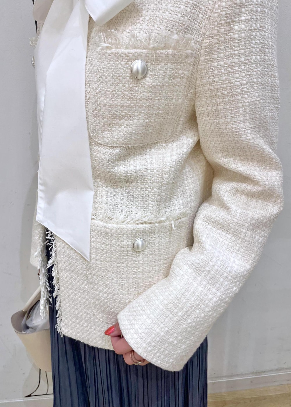 ブルー系のスカート、ベージュ系のローファー、ホワイト系のショルダーバッグを着用したレディースの冬コーディネートの6枚目の写真