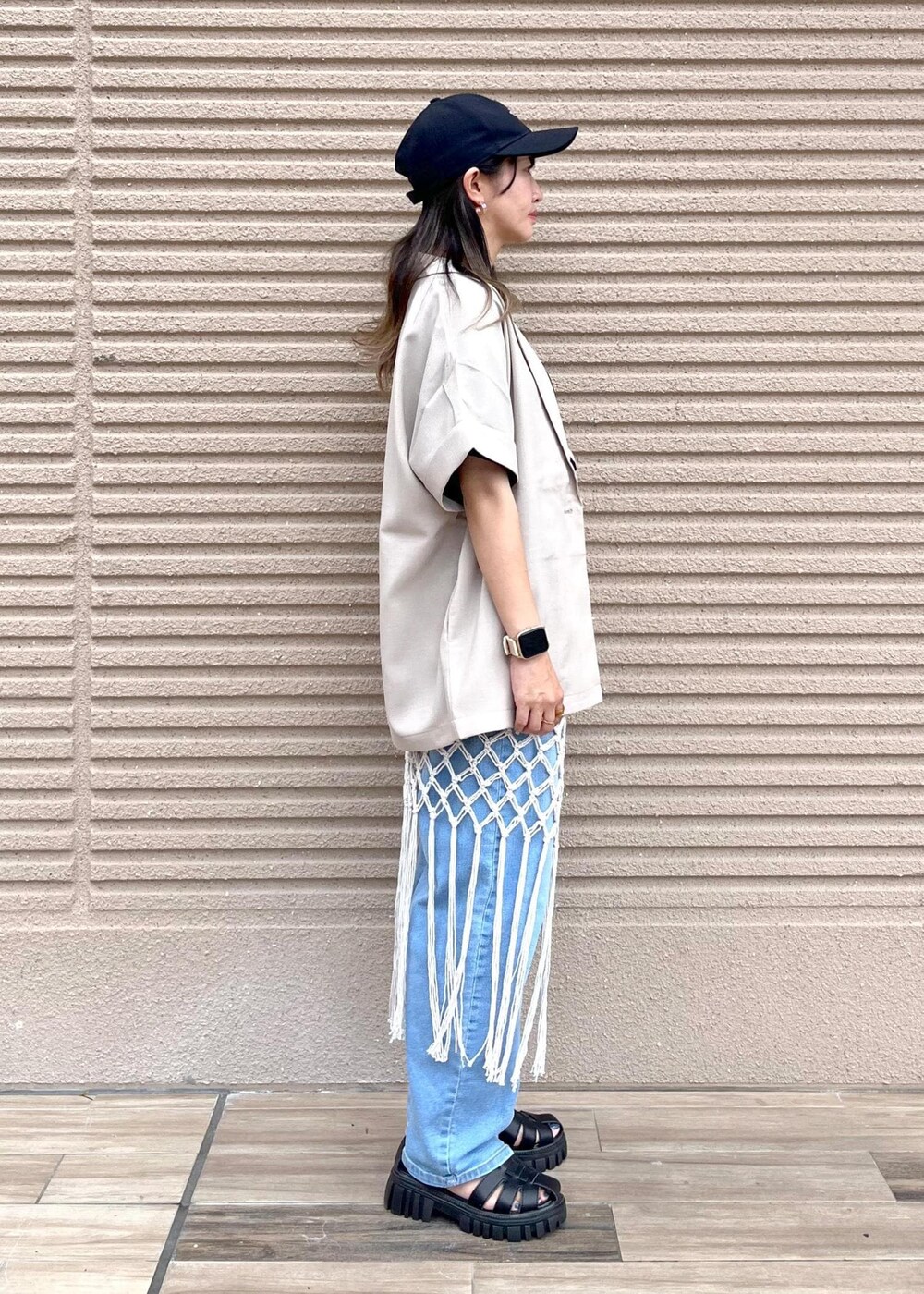 ブルー系のデニムパンツ、ホワイト系のスカート、ブラック系のTシャツ/カットソーを着用したレディースの春コーディネートの4枚目の写真