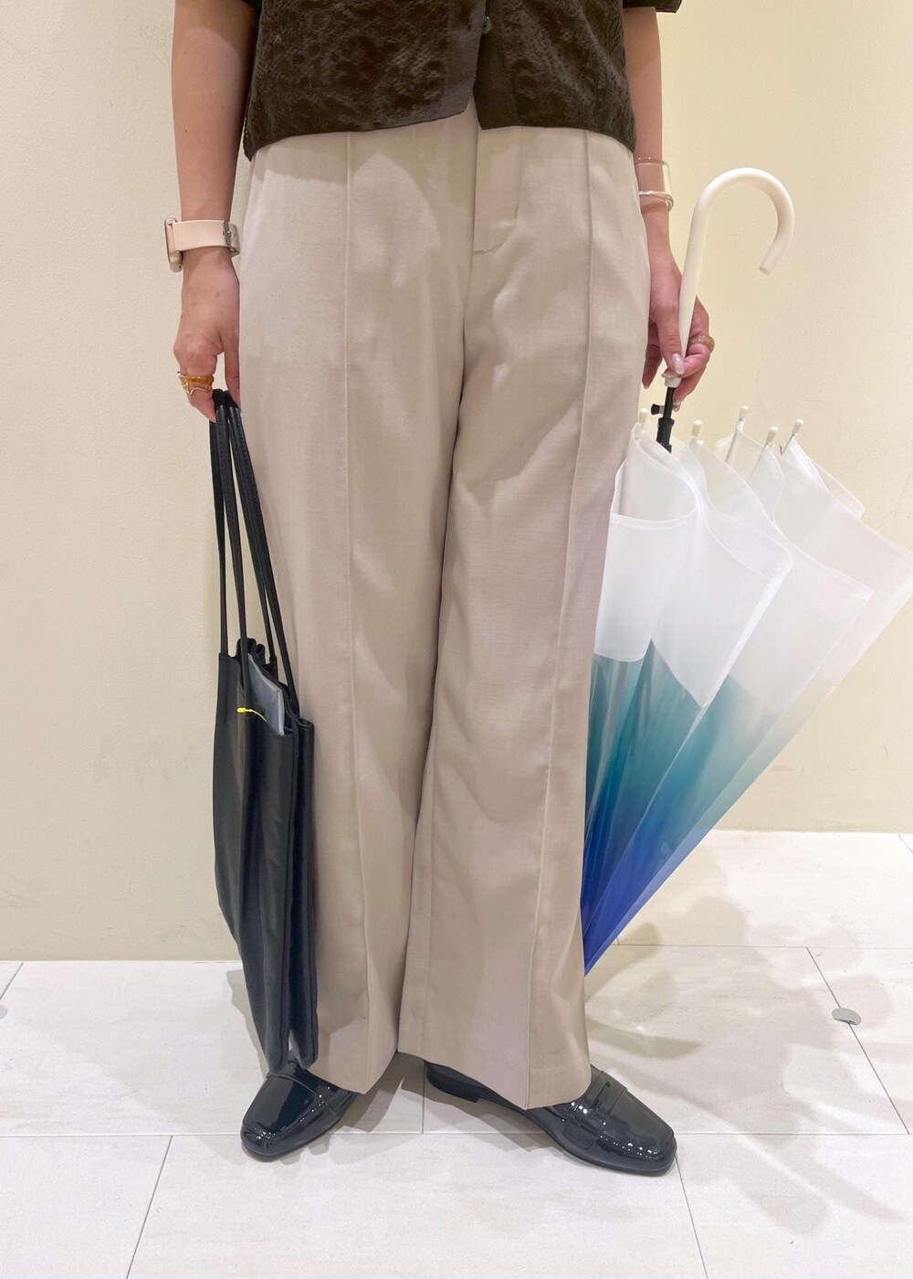 ブラック系のレインシューズ、ブラック系のトートバッグ、ベージュ系のその他パンツを着用したレディースの夏コーディネートの9枚目の写真