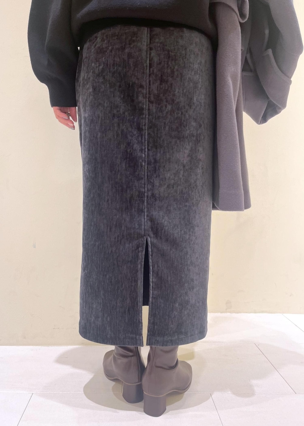 グレー系のスカート、ブラック系のカーディガン/ボレロ、ホワイト系のニット/セーターを着用したレディースの冬コーディネートの7枚目の写真