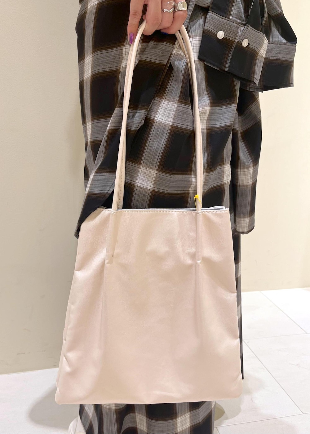 ホワイト系のトートバッグ、ホワイト系のサンダル、ブラック系のワンピースを着用したレディースの夏コーディネートの9枚目の写真