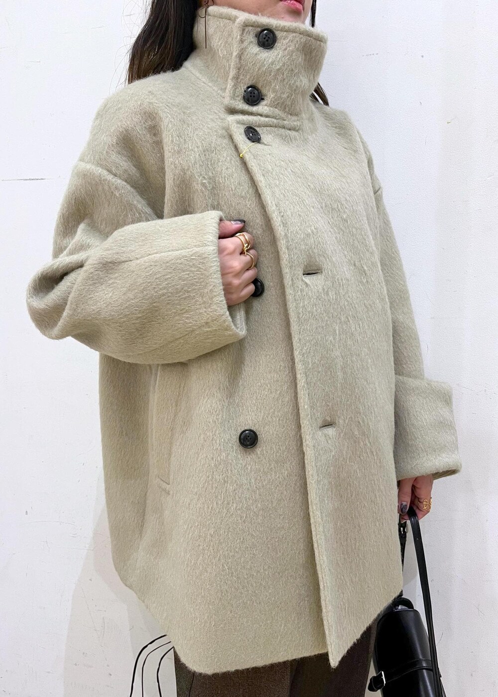 ホワイト系のニット/セーター、グリーン系のその他アウター、ブラウン系のその他パンツを着用したレディースの冬コーディネートの4枚目の写真