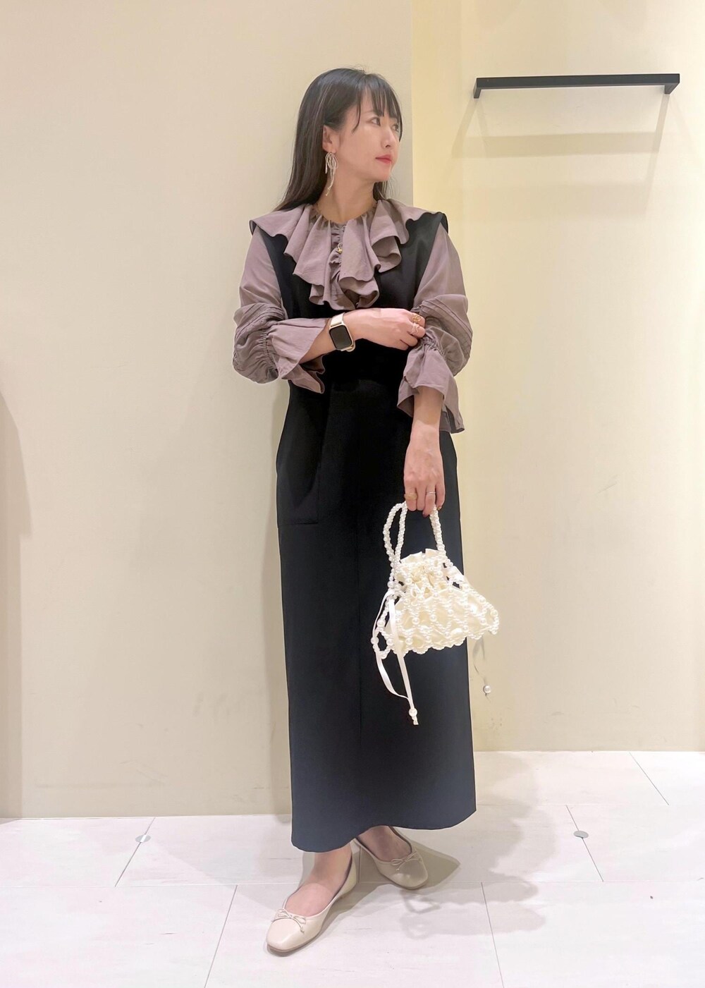 ホワイト系のバレエシューズ、ブラウン系のシャツ/ブラウス、ブラック系のジャンパースカートを着用したレディースの春コーディネートの2枚目の写真