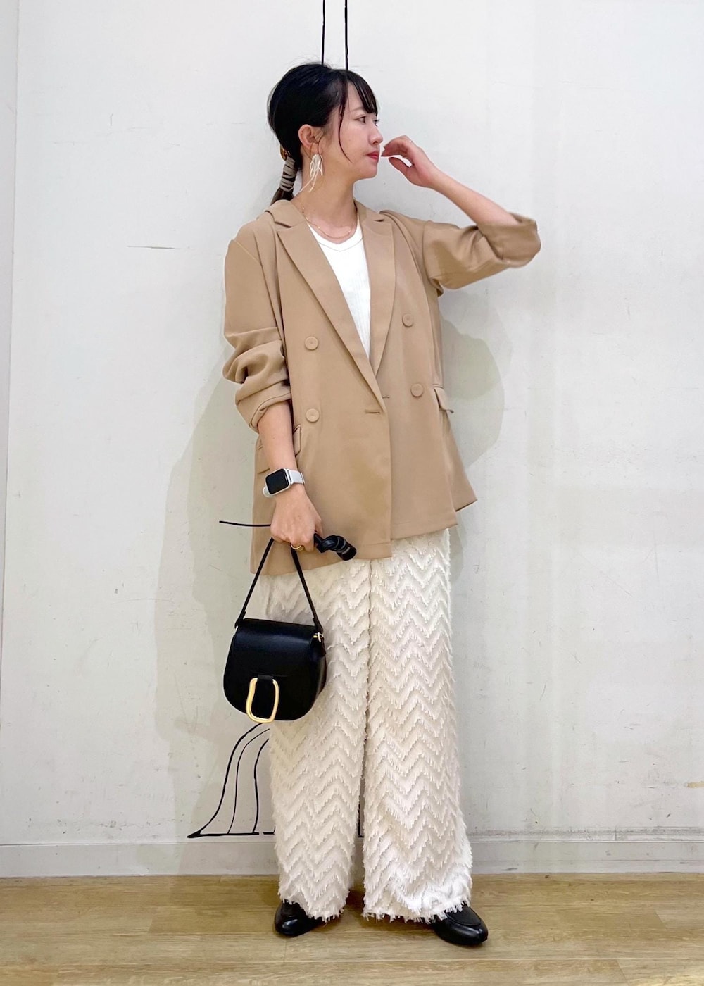 ベージュ系のタンクトップ、ブラック系のショルダーバッグ、ベージュ系のその他パンツを着用したレディースの秋コーディネートの3枚目の写真