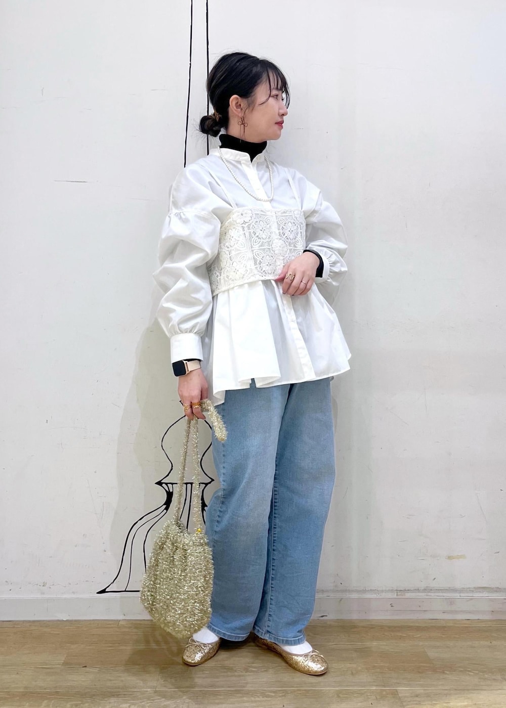 ブラック系のニット/セーター、ゴールド系のバレエシューズ、ホワイト系のキャミソールを着用したレディースの冬コーディネートの2枚目の写真