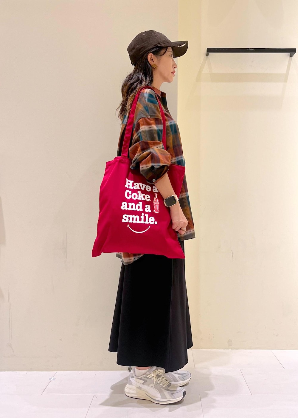 ブラック系のスカート、オレンジ系のシャツ/ブラウス、レッド系のトートバッグを着用したレディースの秋コーディネートの2枚目の写真