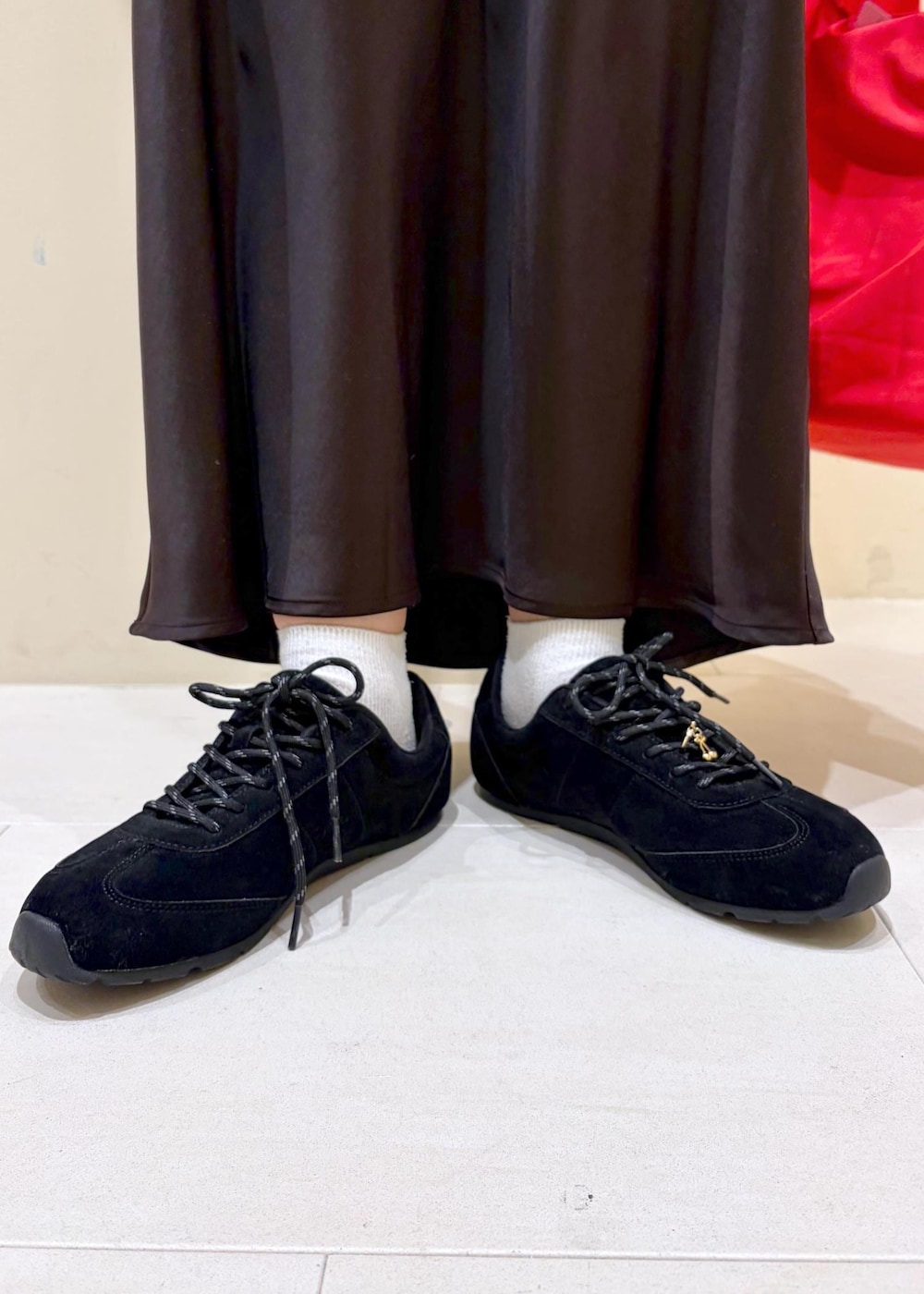 ホワイト系のTシャツ/カットソー、ブラック系のスニーカー、ブラウン系のスカートを着用したレディースの冬コーディネートの10枚目の写真