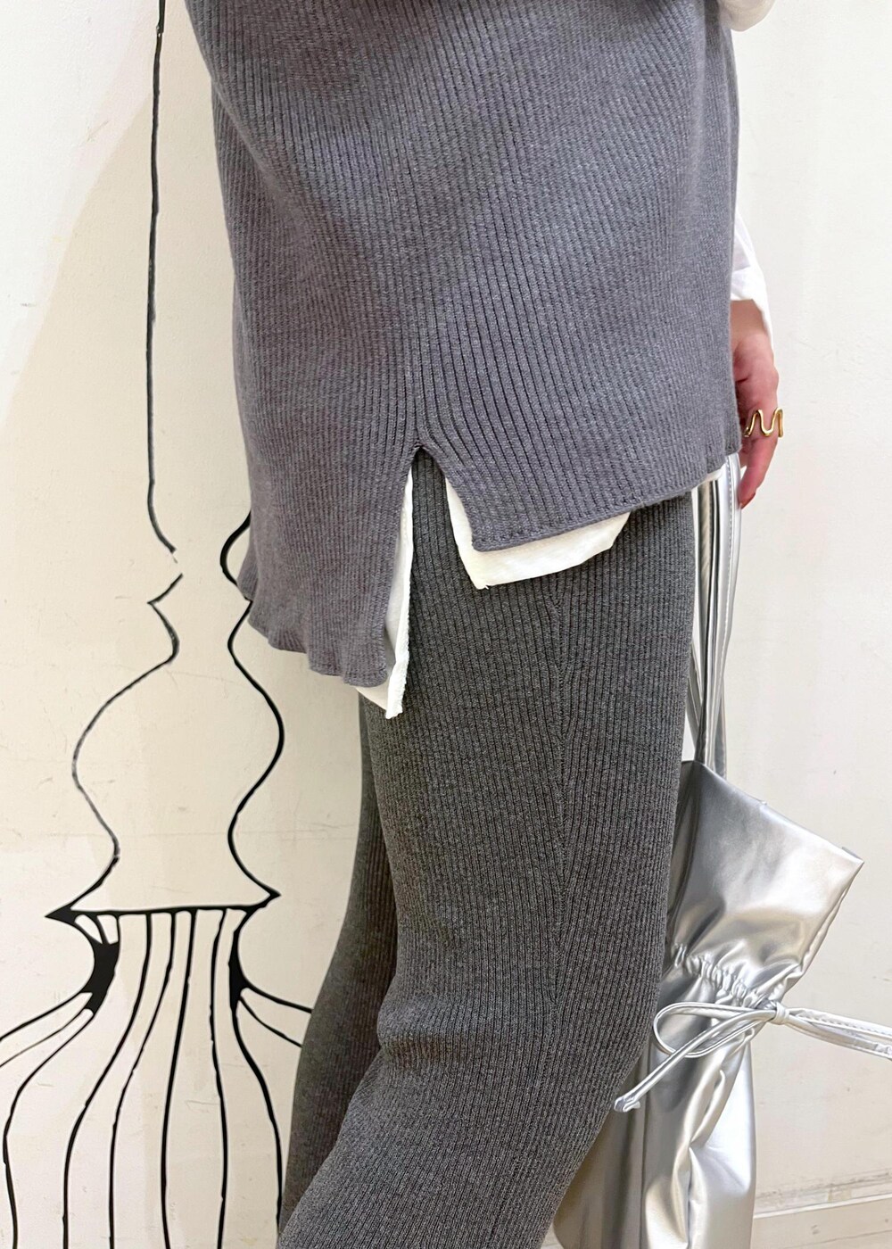 シルバー系のパンプス、グレー系のその他パンツ、シルバー系のトートバッグを着用したレディースの秋コーディネートの7枚目の写真