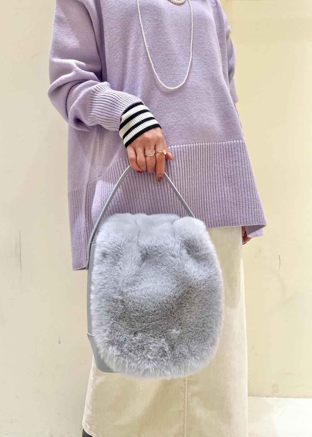 ホワイト系のスカート、パープル系のニット/セーター、ホワイト系のニット/セーターを着用したレディースの冬コーディネートの6枚目の写真