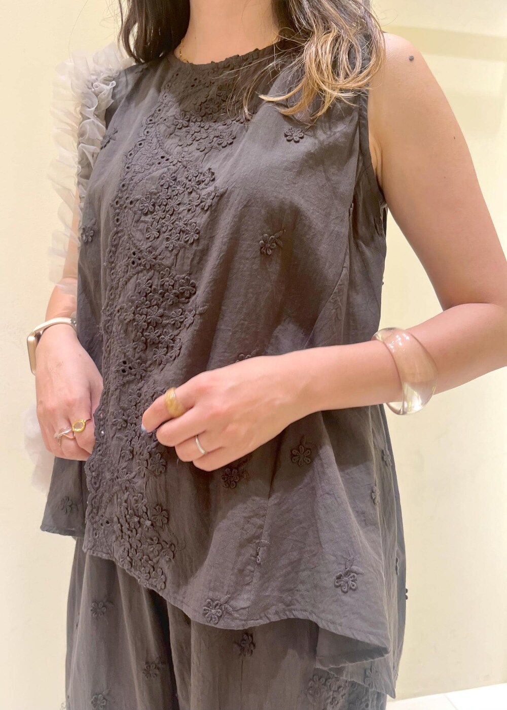 ベージュ系のショルダーバッグ、ゴールド系のサンダル、ブラック系のシャツ/ブラウスを着用したレディースの夏コーディネートの5枚目の写真