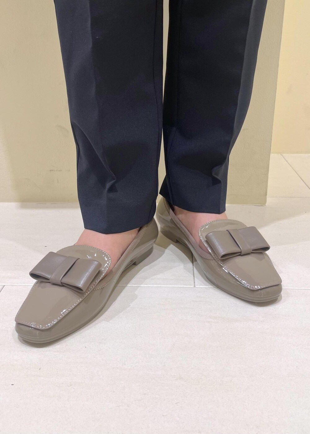 ブルー系のスラックス、ベージュ系のショルダーバッグ、ブラック系のカーディガン/ボレロを着用したレディースの夏コーディネートの10枚目の写真