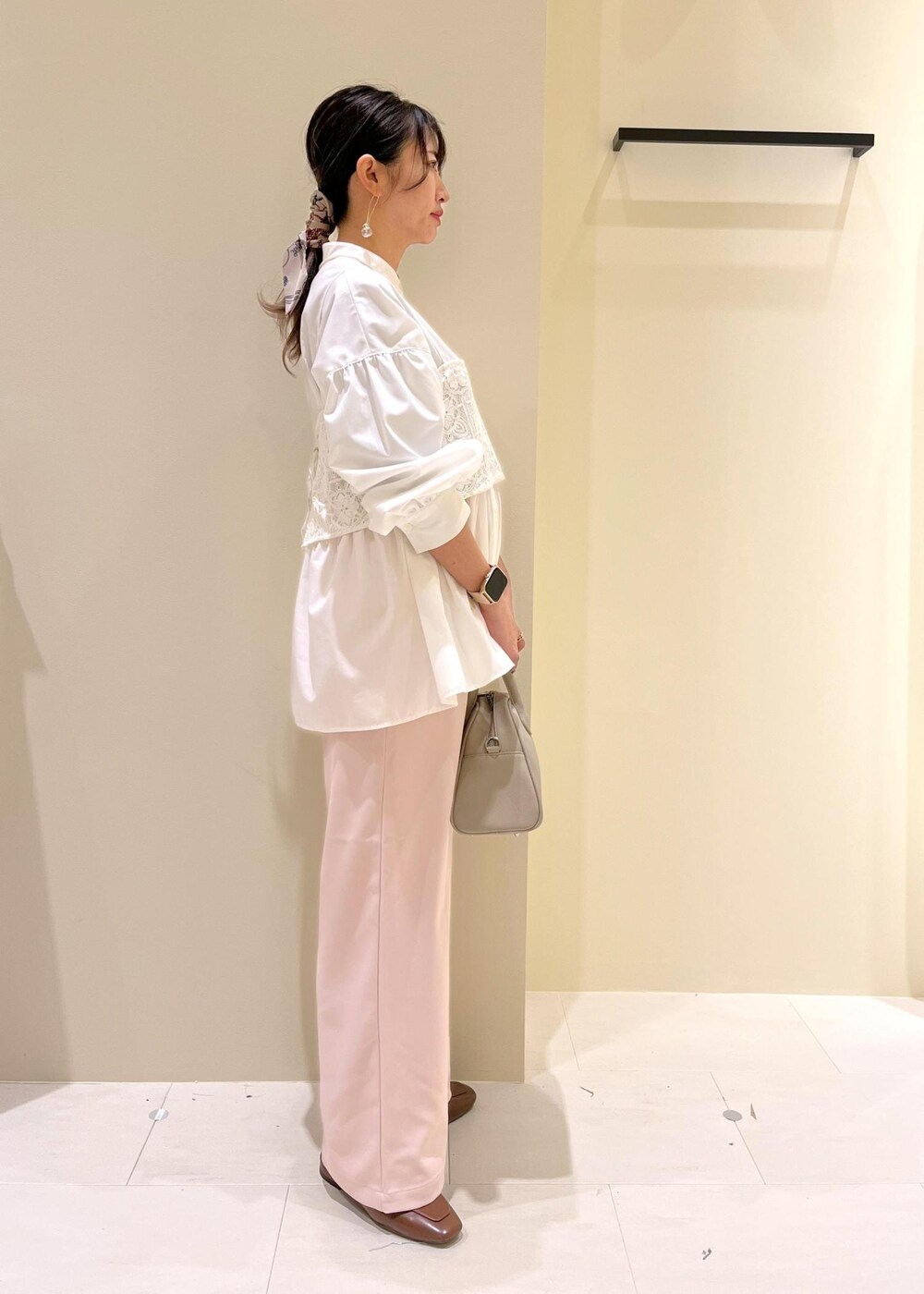 ホワイト系のキャミソール、ホワイト系のシャツ/ブラウス、ベージュ系のボストンバッグを着用したレディースの春コーディネートの3枚目の写真