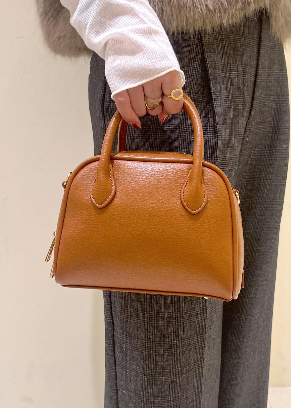 ブラウン系のベスト、ホワイト系のTシャツ/カットソー、グレー系のスラックスを着用したレディースの秋コーディネートの10枚目の写真