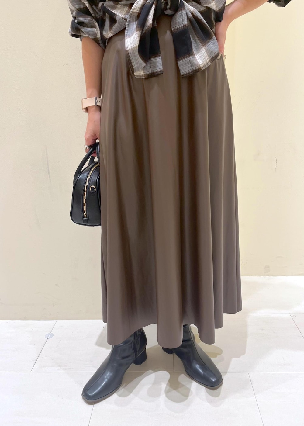 ブラック系のシャツ/ブラウス、グリーン系のスカート、ブラック系のブーツを着用したレディースの秋コーディネートの8枚目の写真