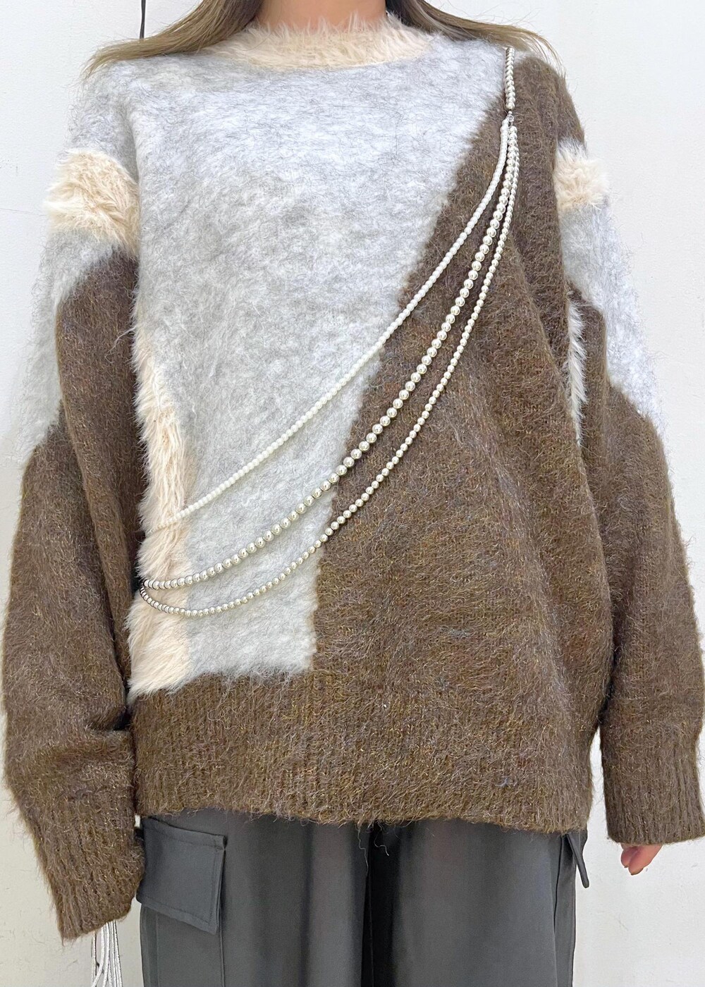 グレー系のカーゴパンツ、シルバー系のショルダーバッグ、ブラウン系のニット/セーターを着用したレディースの秋コーディネートの5枚目の写真