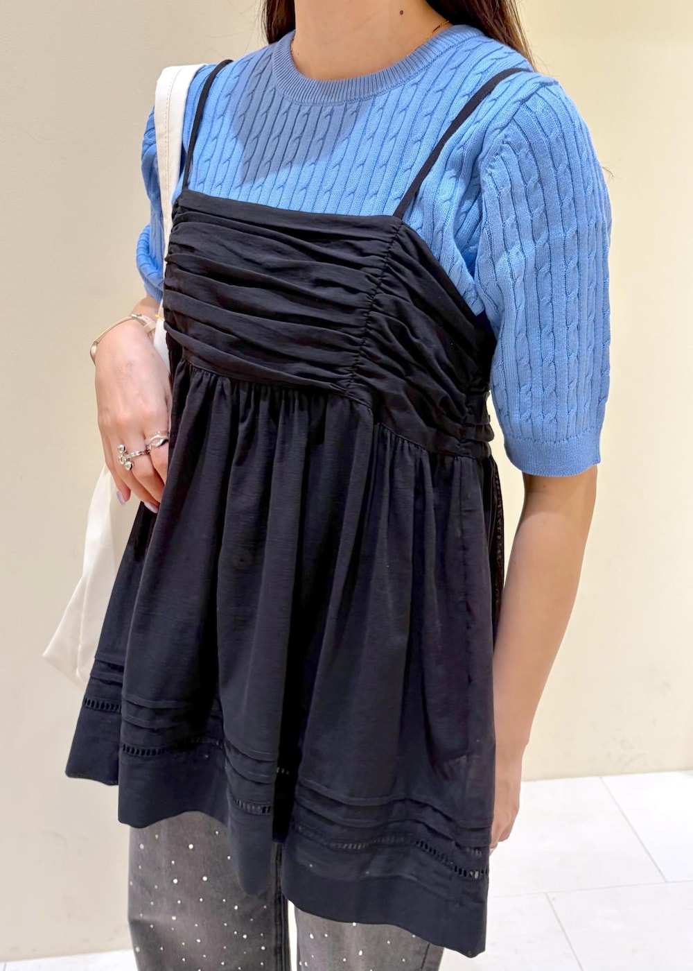 ブラック系のシャツ/ブラウス、ブルー系のニット/セーター、ブラック系のサンダルを着用したレディースの春コーディネートの4枚目の写真