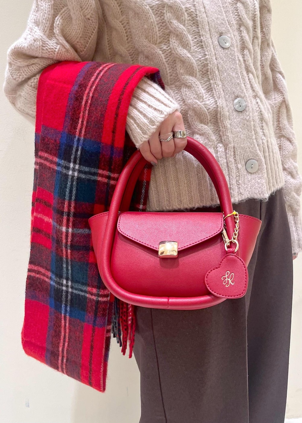 ホワイト系のニット/セーター、レッド系のショルダーバッグ、ブラック系のローファーを着用したレディースの冬コーディネートの8枚目の写真