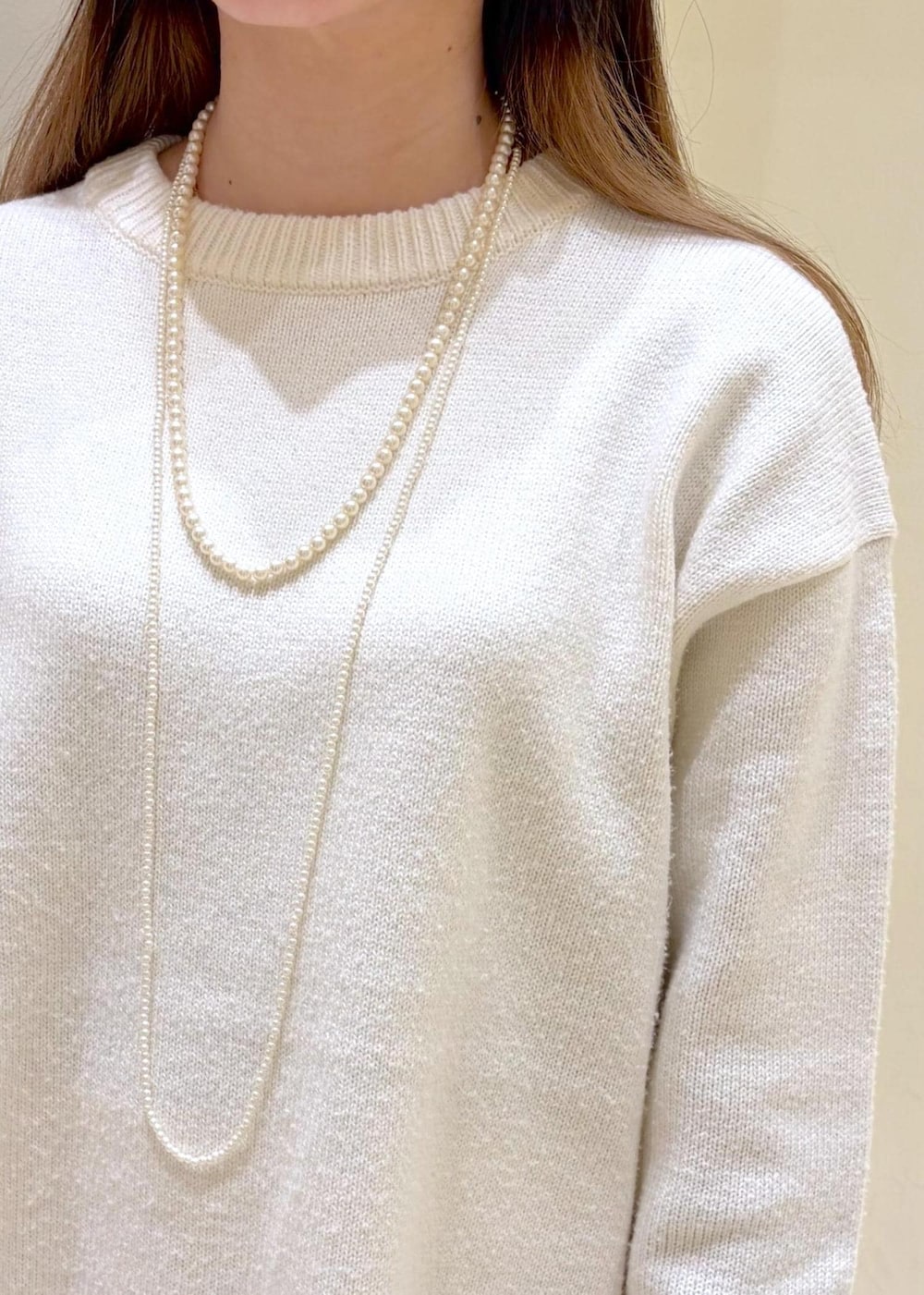 ホワイト系のバレエシューズ、ホワイト系のニット/セーター、ホワイト系のボストンバッグを着用したレディースの冬コーディネートの5枚目の写真