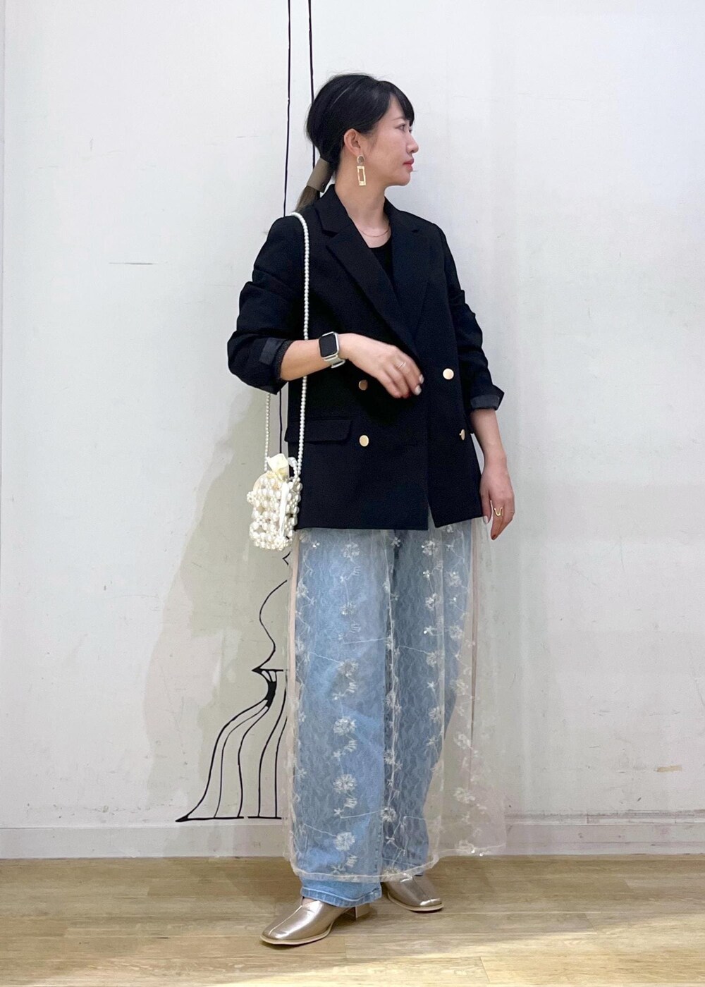 ホワイト系のスカート、ブラック系のニット/セーター、ブラック系のテーラードジャケットを着用したレディースの秋コーディネートの2枚目の写真