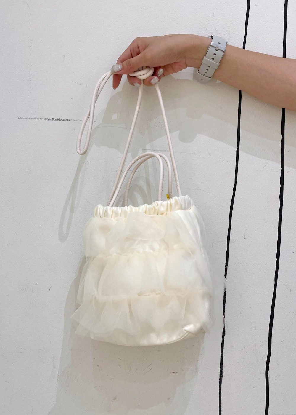 シルバー系のスカート、ブラック系のTシャツ/カットソー、ホワイト系のサンダルを着用したレディースの夏コーディネートの9枚目の写真