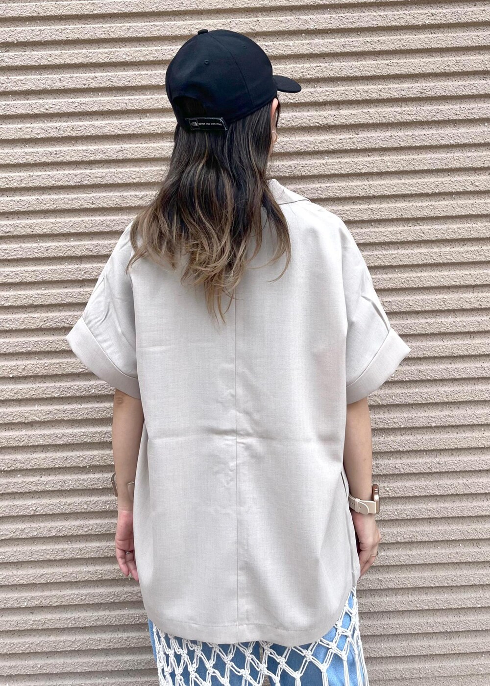 ブルー系のデニムパンツ、ホワイト系のスカート、ブラック系のTシャツ/カットソーを着用したレディースの春コーディネートの8枚目の写真