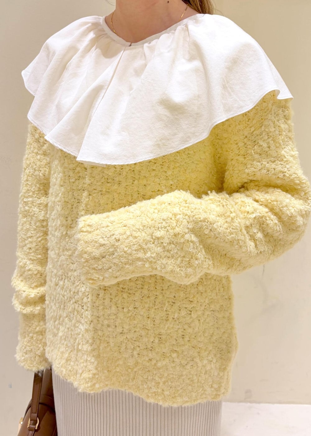 シルバー系のバレエシューズ、ホワイト系のシャツ/ブラウス、イエロー系のニット/セーターを着用したレディースの冬コーディネートの6枚目の写真