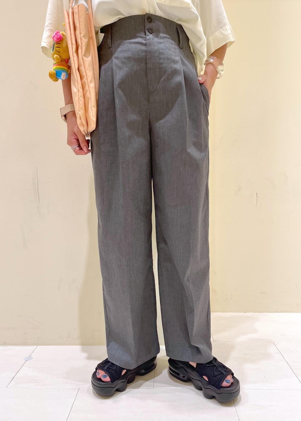 ピンク系のトートバッグ、グレー系のチノパンツ、ホワイト系のシャツ/ブラウスを着用したレディースの夏コーディネートの9枚目の写真