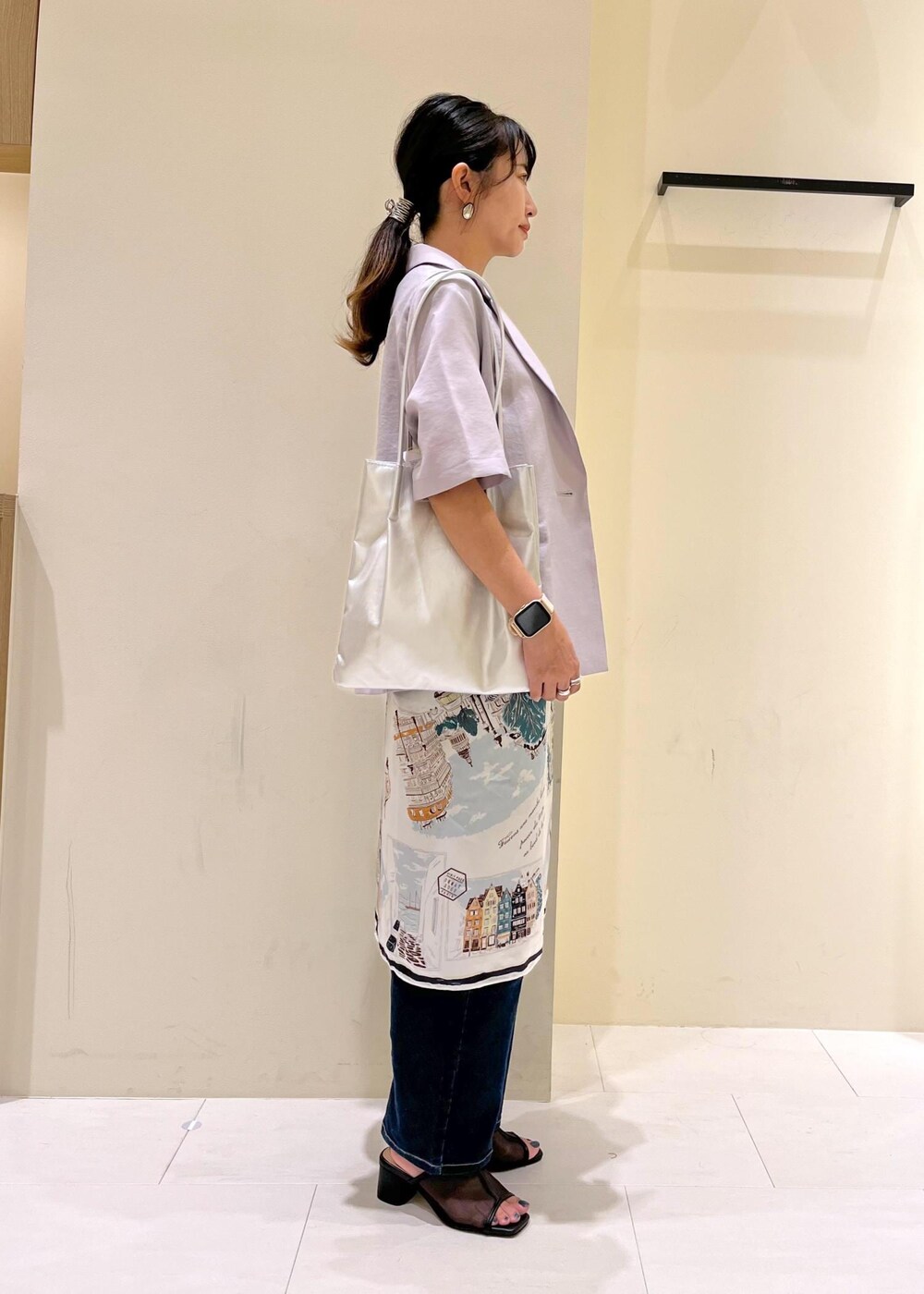 ブルー系のデニムパンツ、シルバー系のトートバッグ、ブラック系のパンプスを着用したレディースの夏コーディネートの2枚目の写真