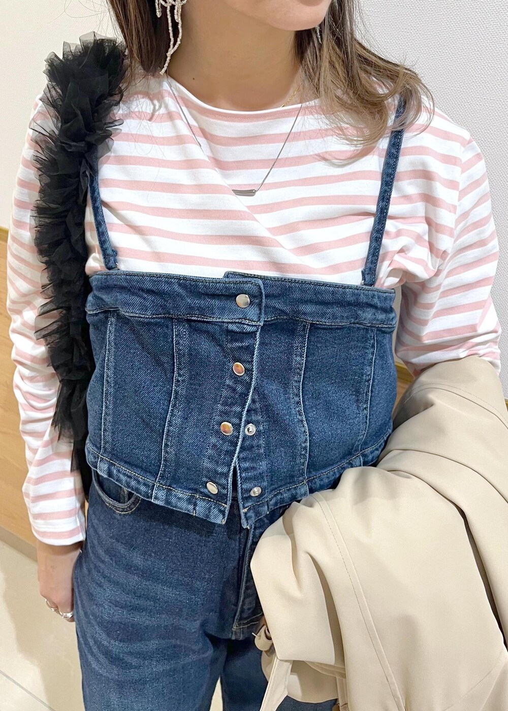 ブルー系のデニムパンツ、ブラック系のショルダーバッグ、ピンク系のTシャツ/カットソーを着用したレディースの春コーディネートの5枚目の写真