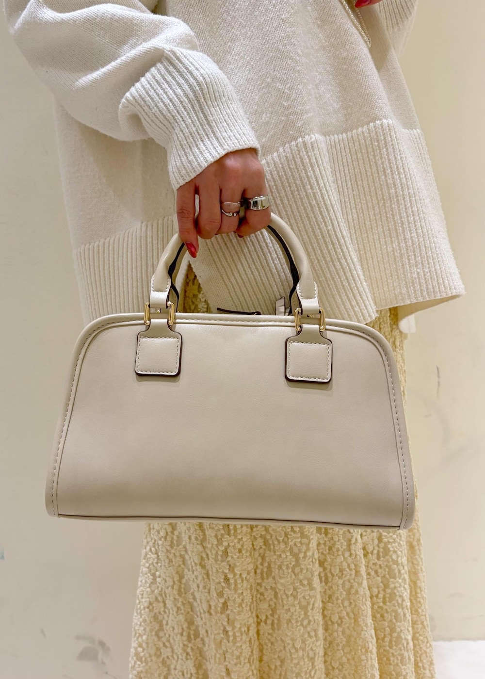 ホワイト系のバレエシューズ、ホワイト系のニット/セーター、ホワイト系のボストンバッグを着用したレディースの冬コーディネートの9枚目の写真