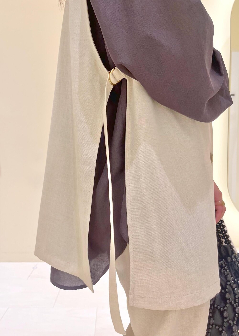 イエロー系のローファー、ブラック系のハンドバッグ、ベージュ系のベストを着用したレディースの春コーディネートの8枚目の写真